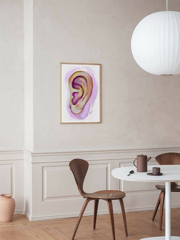 a painting hanging on the wall next to two chairs and a table in a room