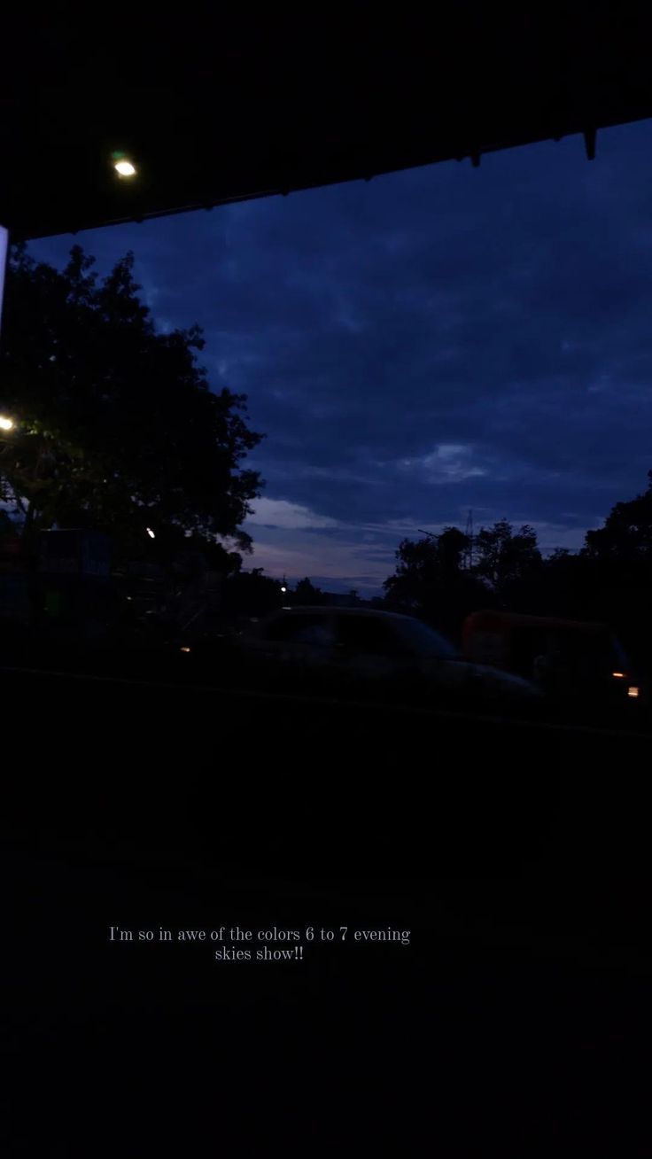 a street sign is lit up at night with the sky in the backgroud