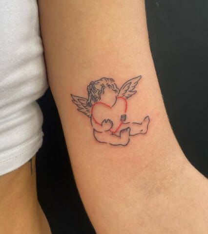 a small tattoo of an angel holding a heart