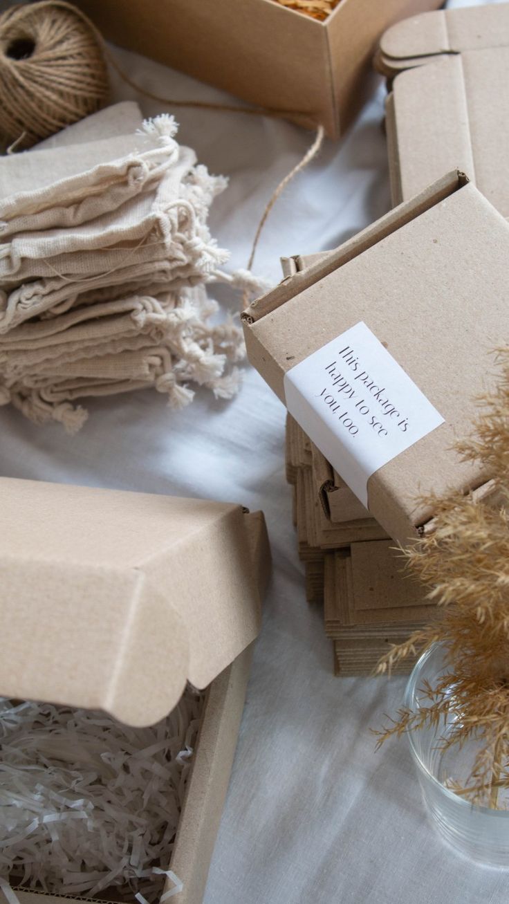 several boxes are stacked next to each other on a table with yarn and flowers in them