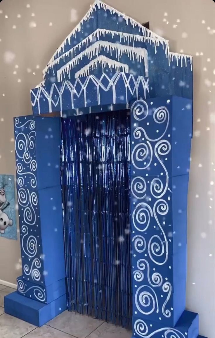 a blue door decorated with snow and icing on the outside, in front of a wall