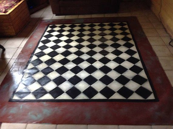 a black and white checkered rug in the middle of a living room with tile flooring