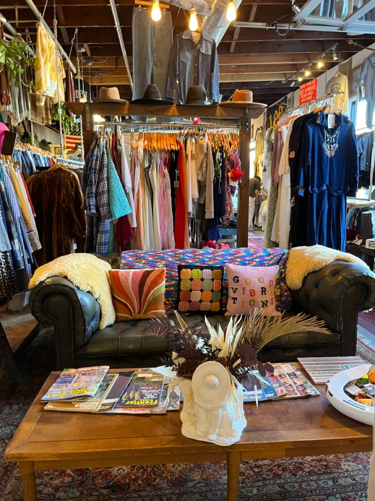 a living room filled with furniture and lots of clothes