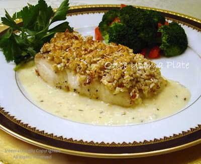 a white plate topped with fish covered in gravy next to broccoli