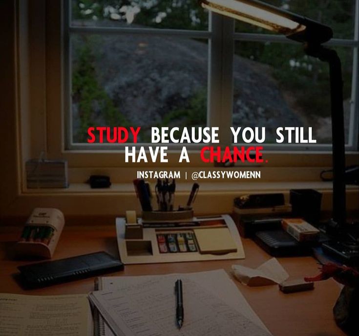 a desk with a lamp, pen and notebook on it next to a window that reads study because you still have a chance