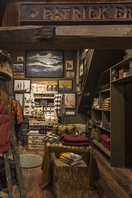 a man standing on a ladder in a room filled with pictures and other items,