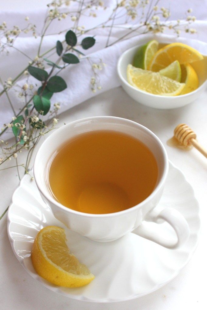 a cup of tea with lemon and honey on the side