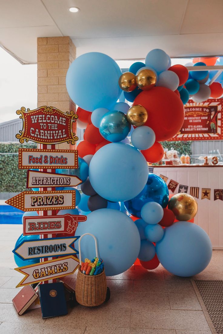 a bunch of balloons that are on top of a sign post in front of a building