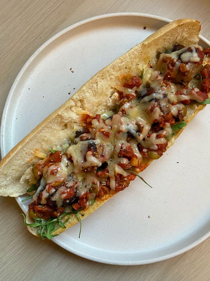 a taco on a white plate sitting on a table