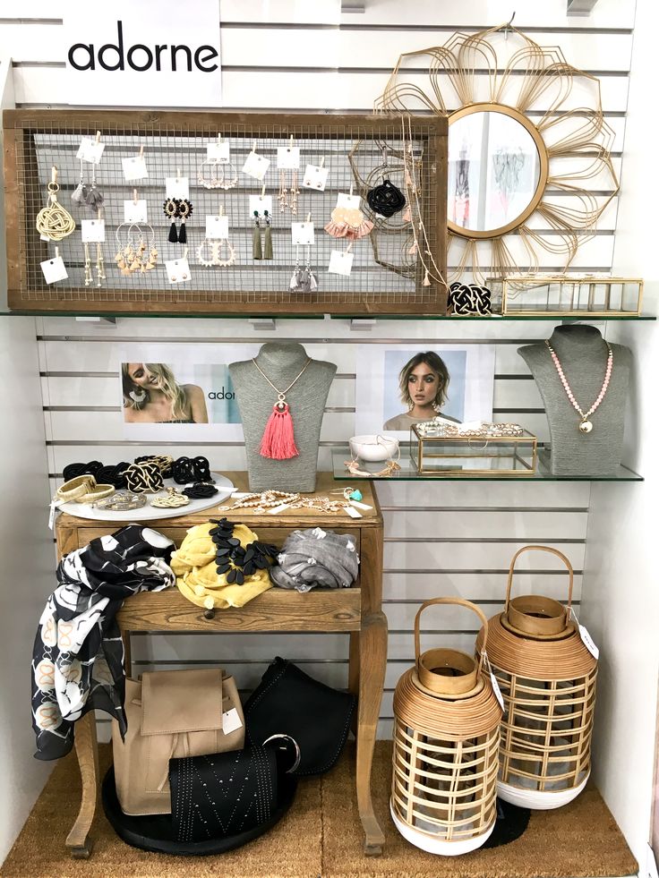 an assortment of clothing and accessories on display in a store with the name adorne above it