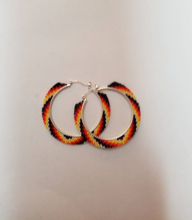 fire colours beaded hoop earrings. 1.5 in hoop 2 in diameter with beadwork. made with size 15 seed beads. Native Beaded Hoop Earrings, Multicolor Small Hoop Jewelry With Spacer Beads, Orange Beaded Hoop Earrings As A Gift, Orange Beaded Hoop Earrings For Gift, Orange Hoop Earrings With Colorful Beads, Hoop Beaded Earrings With Spacer Beads, Multicolor Hoop Jewelry With Spacer Beads, Orange Hoop Beaded Earrings As Gift, Yellow Beaded Small Hoop Jewelry