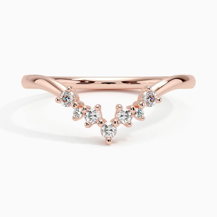 Caris Diamond Wedding Ring - 14K Rose Gold. A stream of glistening offset diamonds meet at a point in this captivating ring, perfectly styled to encircle an engagement ring in an aura of light (1/10 total carat weight). Dazzling Rose Gold Wedding Ring, Wedding 14k Rose Gold Stackable Rings, 14k Rose Gold Stackable Wedding Rings, Rose Gold Half Eternity Diamond Anniversary Ring, 14k Rose Gold Stackable Rings For Wedding, Timeless 14k Rose Gold Wedding Jewelry, Timeless 14k Rose Gold Wedding Rings, Rose Gold Diamond Ring With Diamond Accents, Round Cut, Elegant Stackable Diamond Rings In Rose Gold