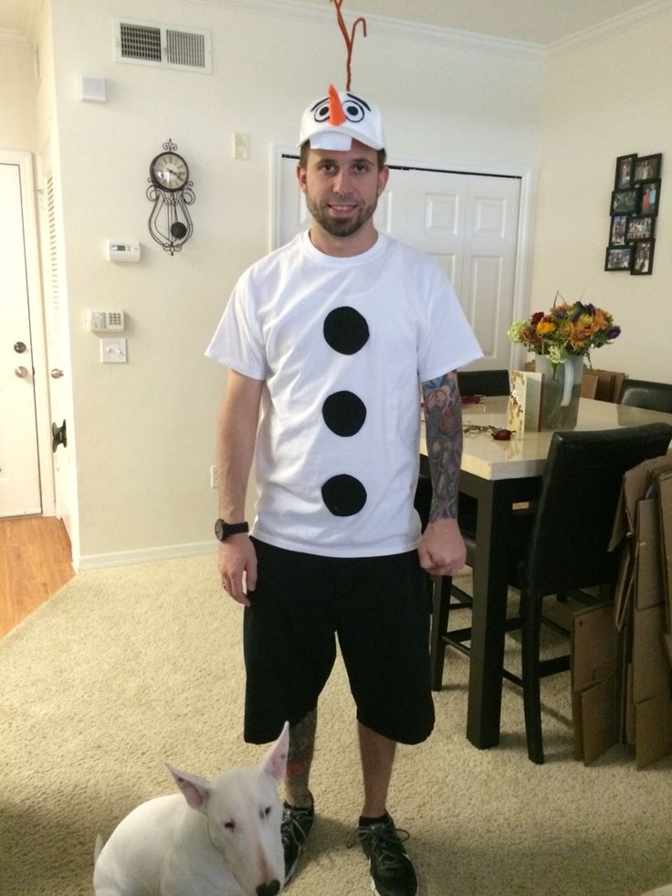 a man standing next to a white dog wearing a snowman t - shirt on his head