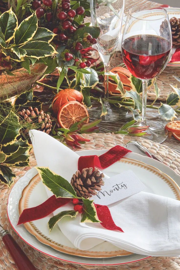 a place setting with pine cones, oranges and holly