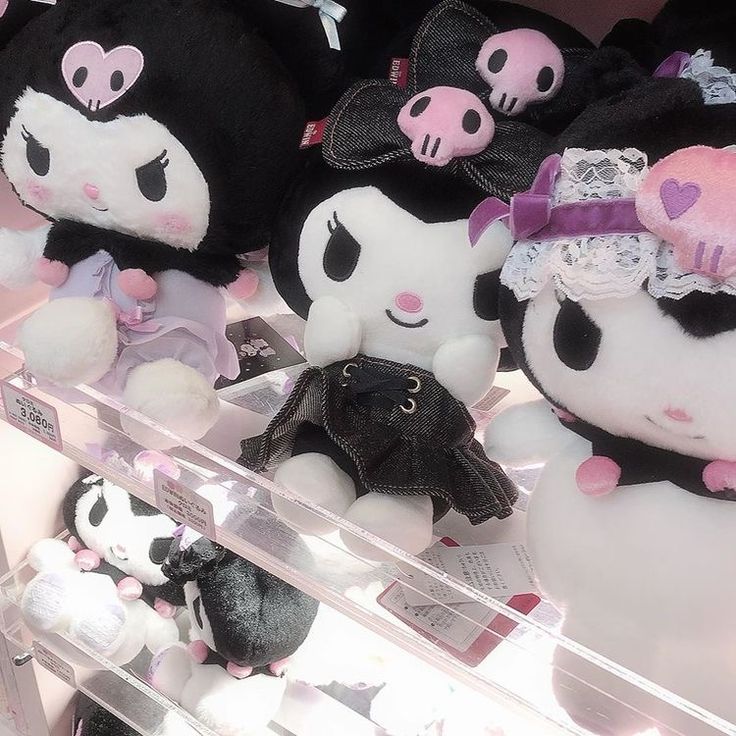 several stuffed animals are on display in a store window, with pink and black accents