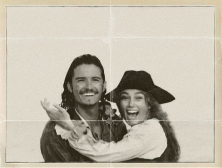 a man and woman are posing for a photo in front of a white background with squares