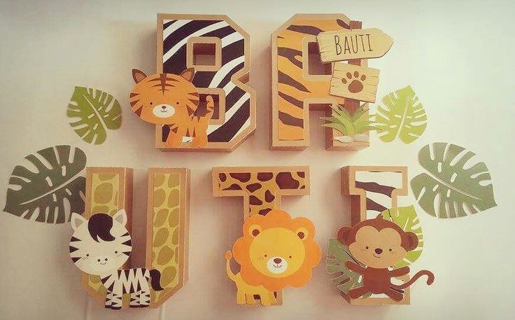 the wooden letters are decorated with animals and plants