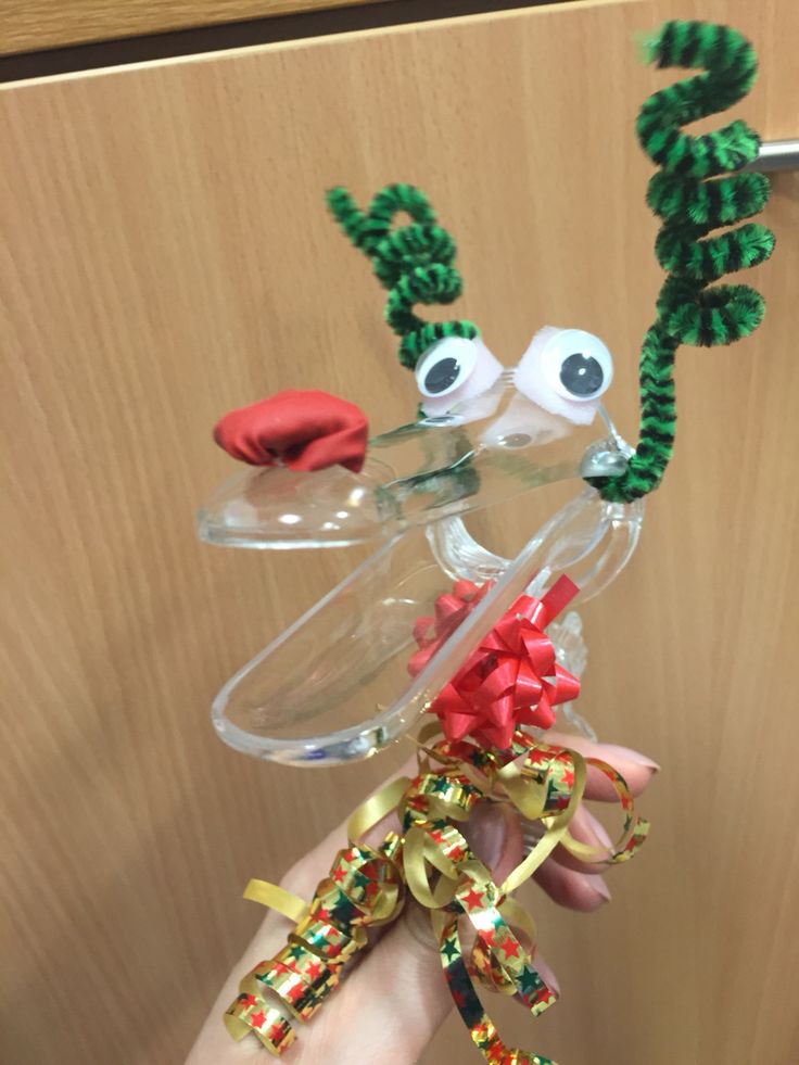 a hand holding a glass vase filled with christmas decorations