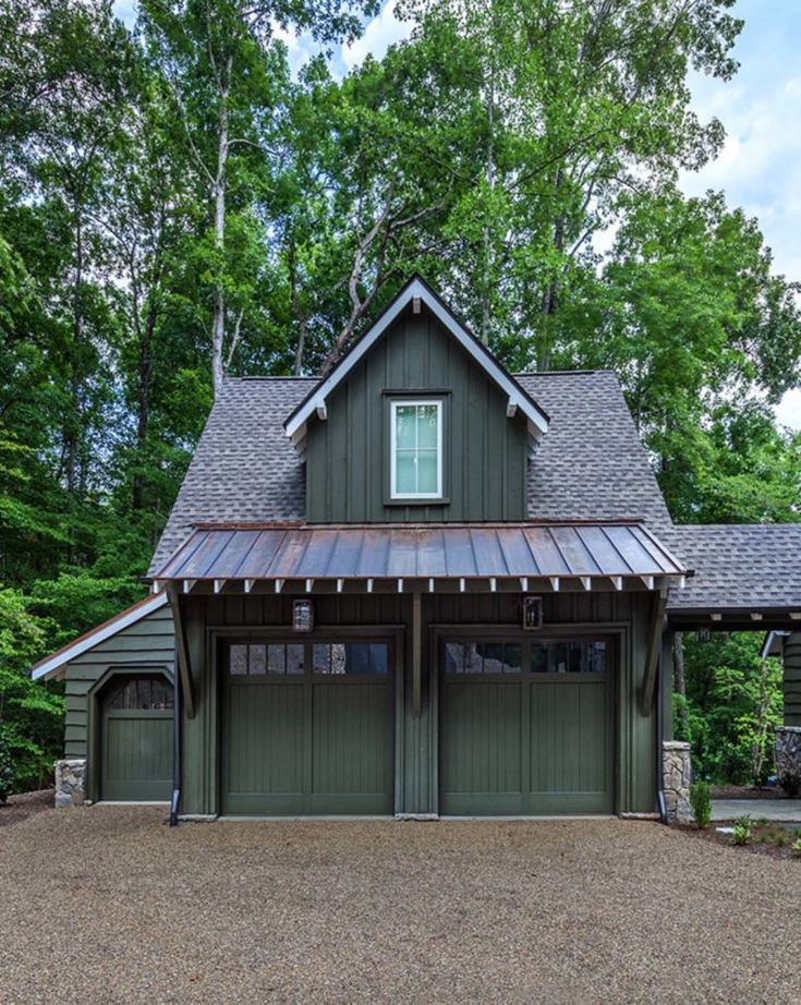 this is an image of a two car garage in front of a wooded area with lots of trees