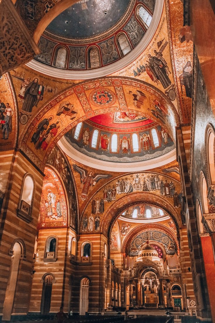 the inside of an old church with many paintings on it's walls and ceiling