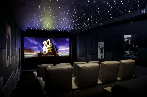 an empty movie theater with white chairs and stars on the ceiling is lit by leds