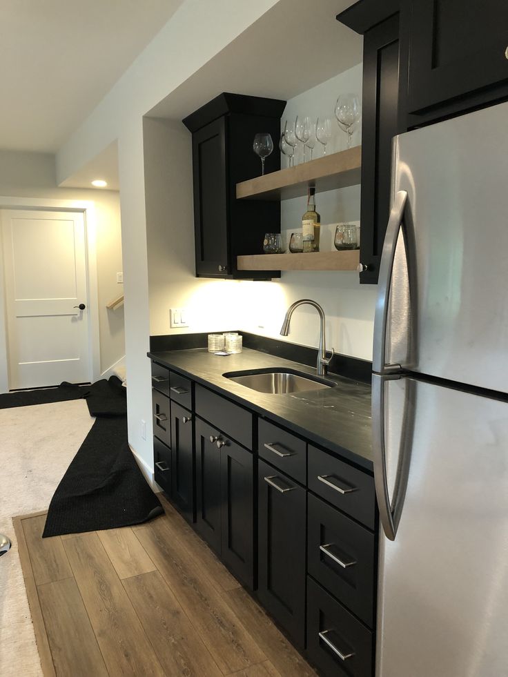 a kitchen with black cabinets and stainless steel appliances