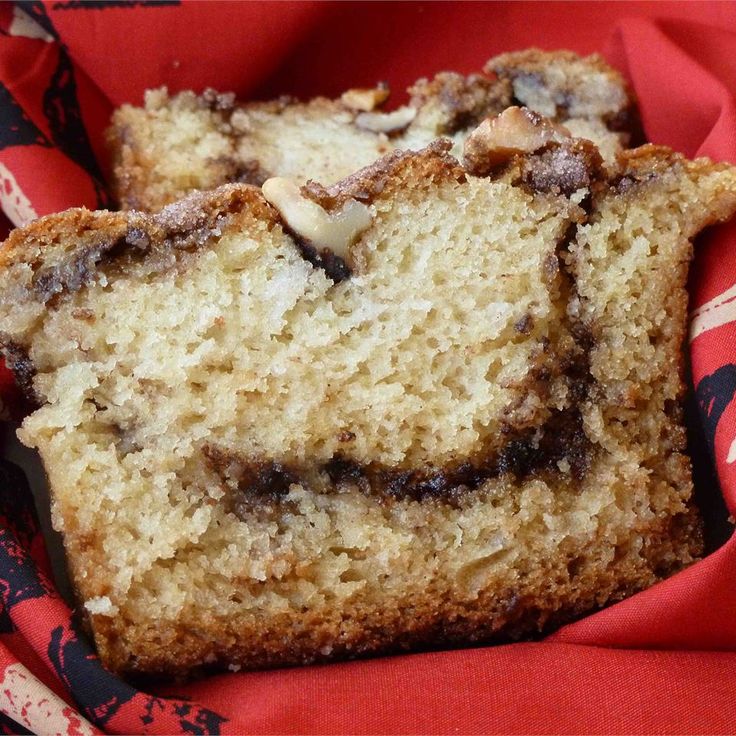 two pieces of cake sitting in a basket on top of a red cloth covered table