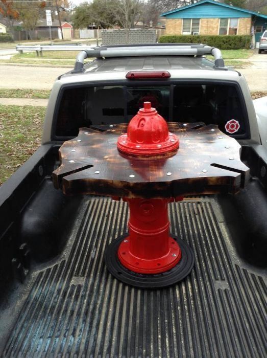 a red fire hydrant sitting in the back of a pickup truck's bed