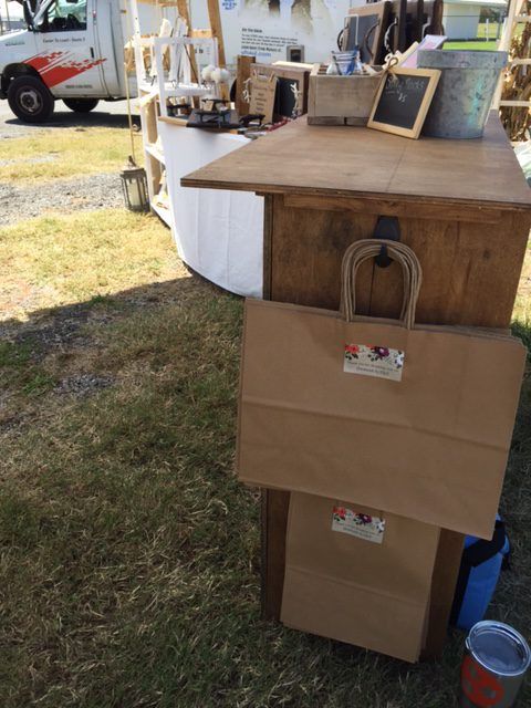 a cardboard box sitting on top of a wooden table next to a white truck and grass