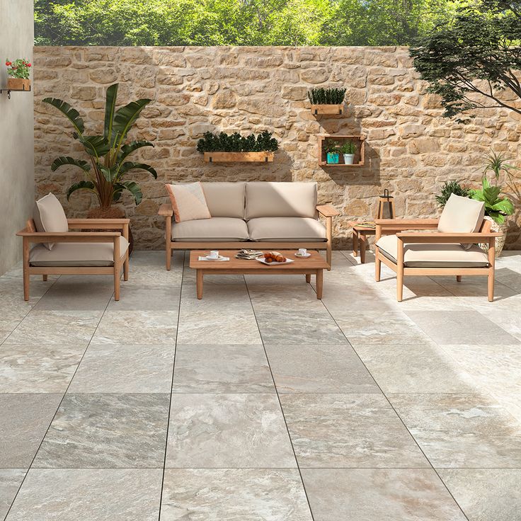 an outdoor living room with stone walls and flooring