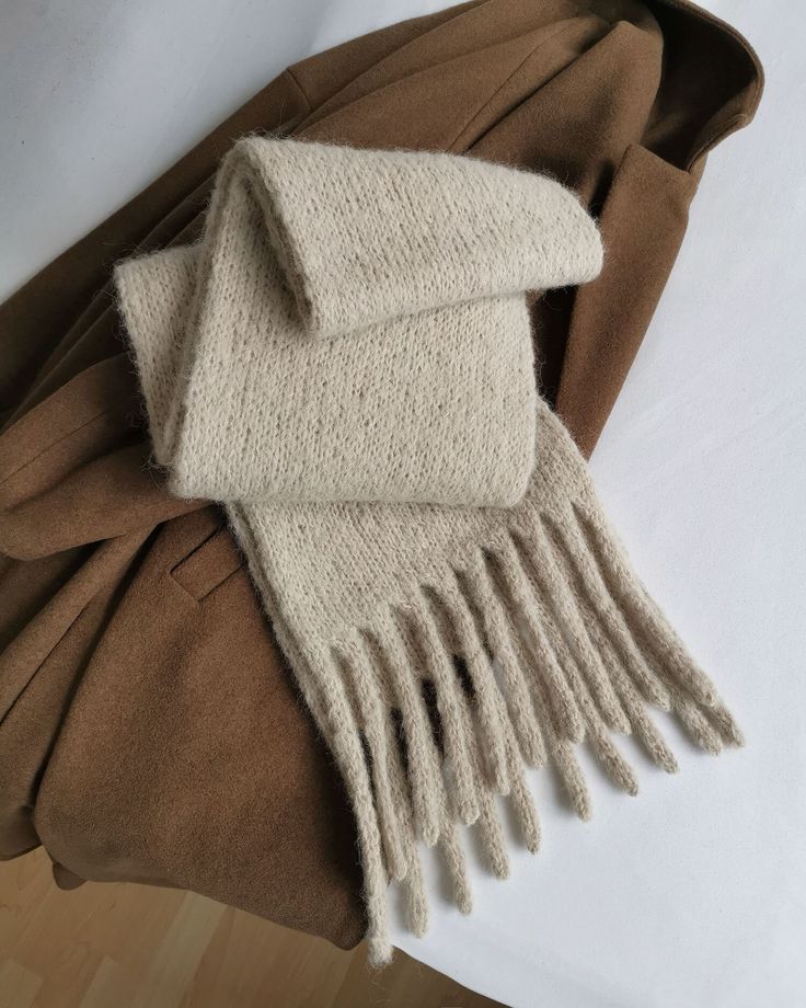 a brown coat and scarf laying on top of each other