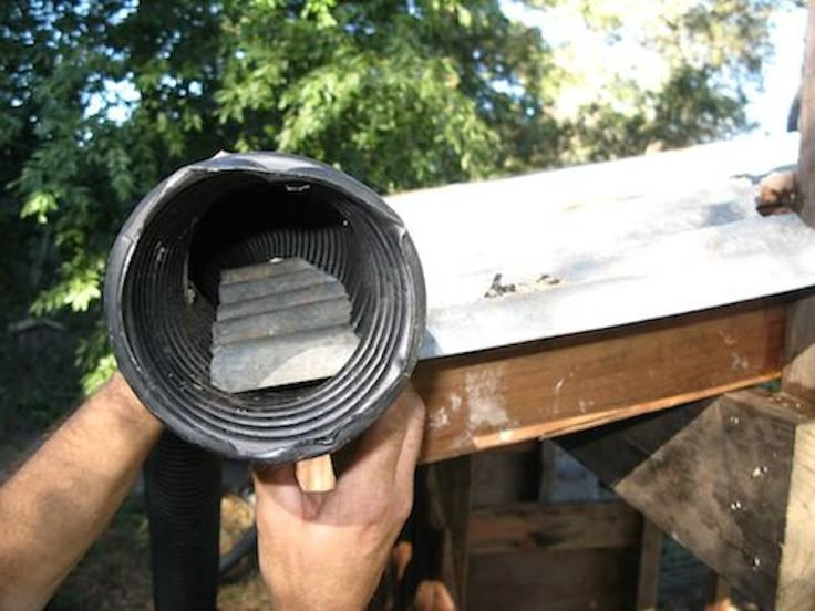 a man is holding a piece of metal in front of his face while working on a project