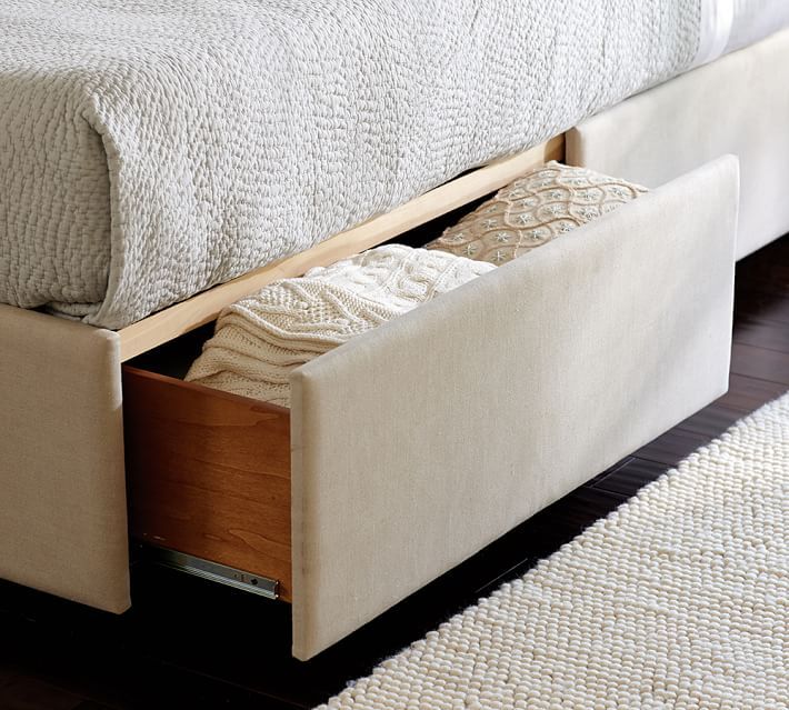 an upholstered bed with two pull out drawers on each side and a rug underneath it