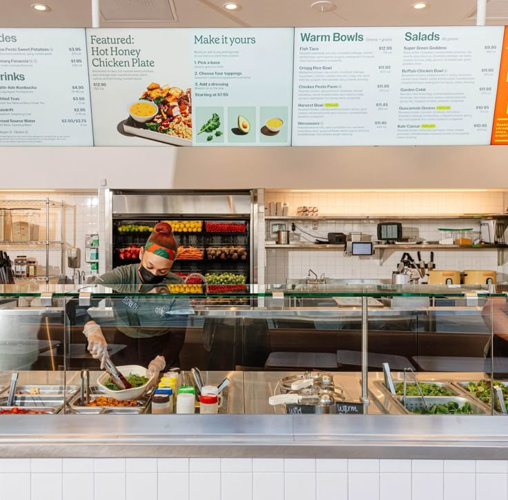 the inside of a fast food restaurant with menus on the wall behind the counter