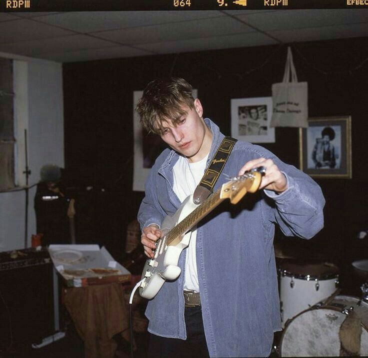 a young man holding a guitar in his hands