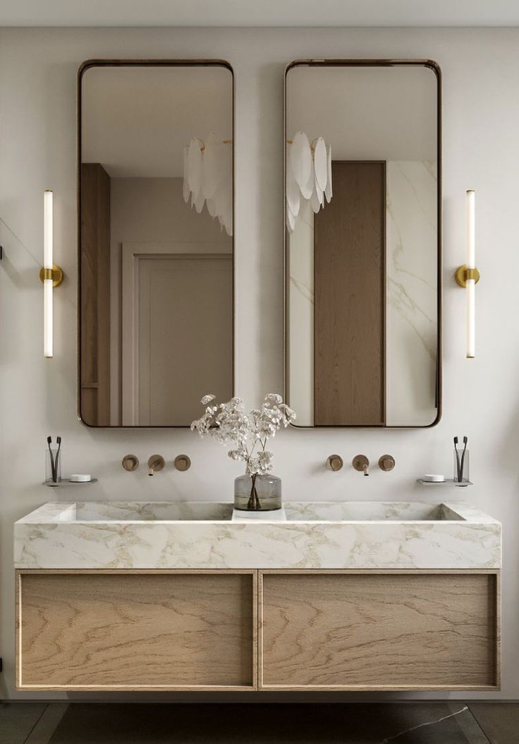 a bathroom with two sinks and mirrors on the wall