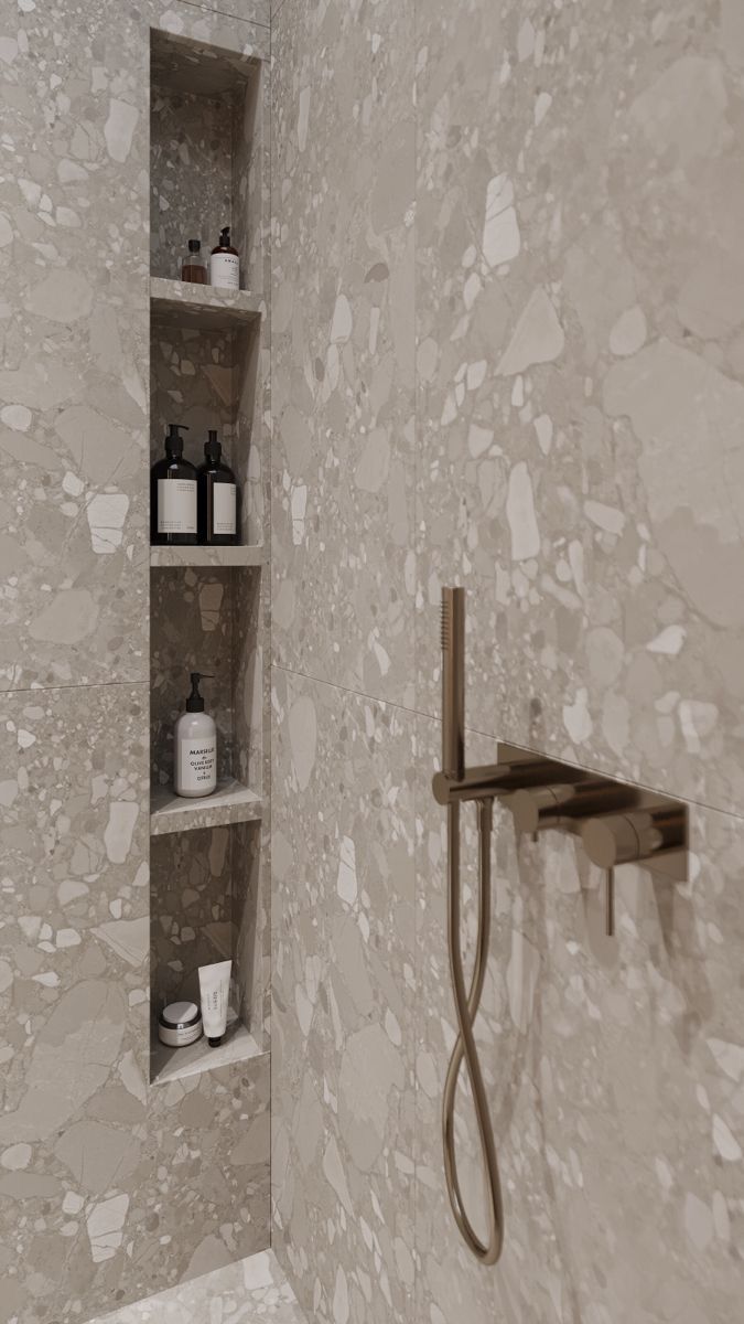 a bathroom with white and beige walls, shelves on the wall and a shower head