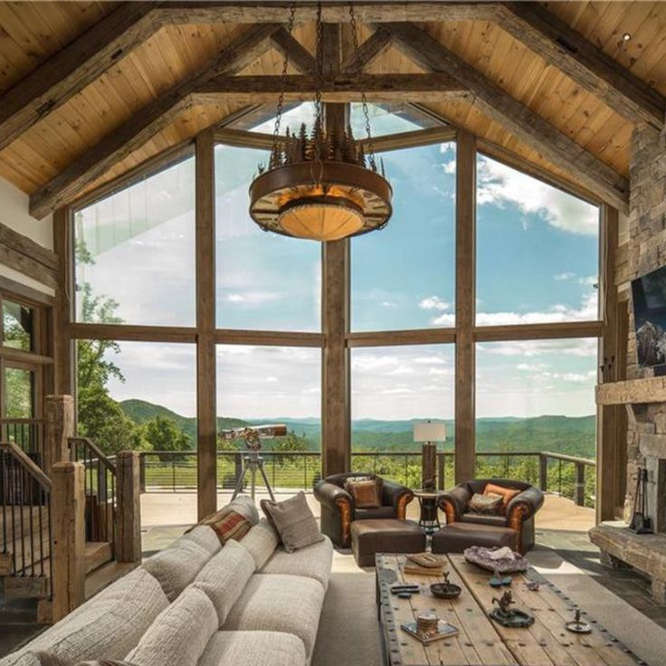 a living room filled with lots of furniture and a fire place in front of a large window