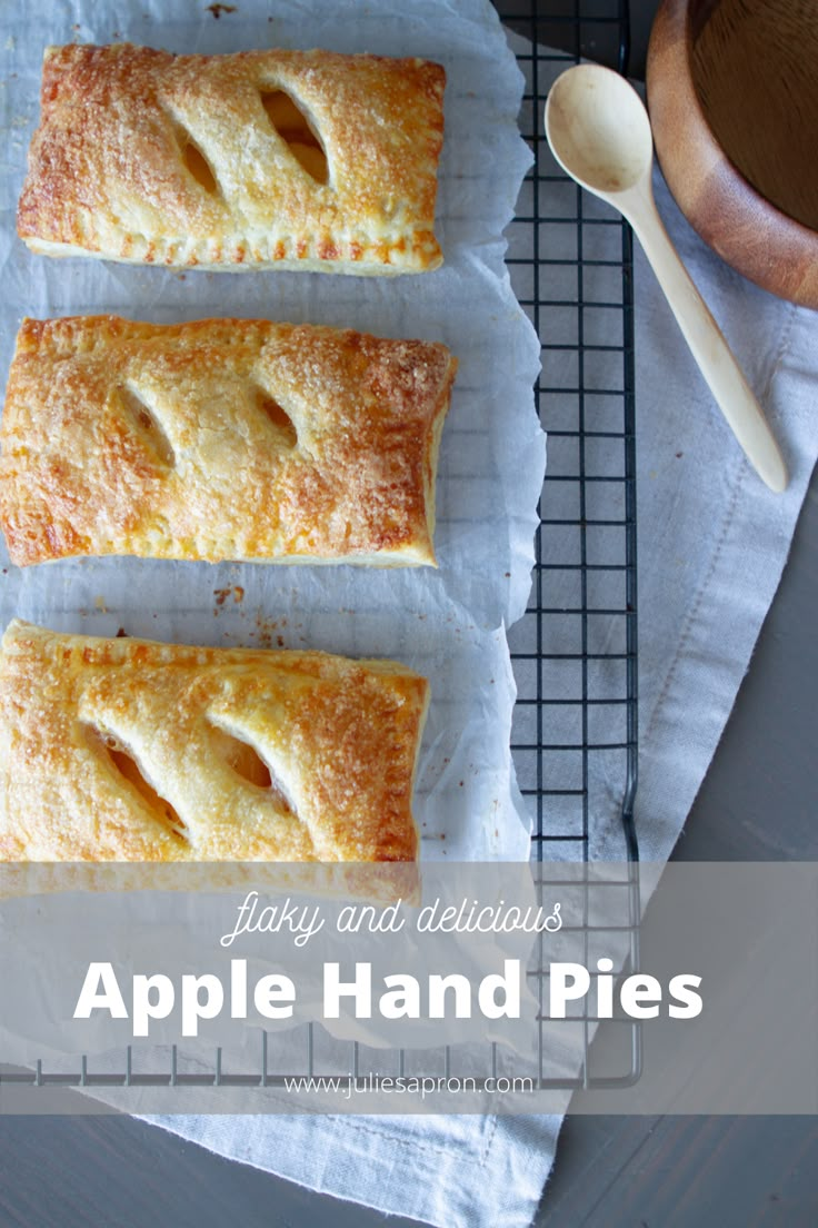 four pastries sitting on top of a cooling rack next to a cup and spoon