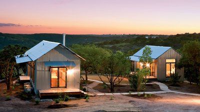 two tiny houses are lit up in the evening