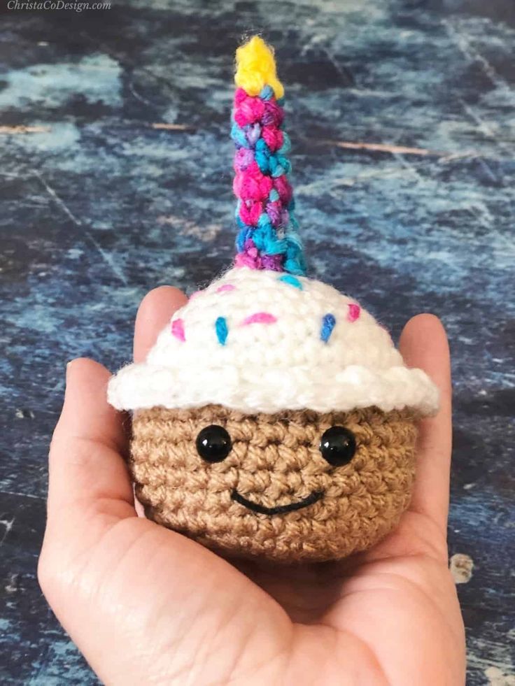 a small crocheted cupcake with a candle sticking out of it's top