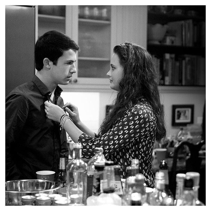 a man helping a woman put on her tie