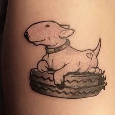 a dog sitting on top of a basket tattoo