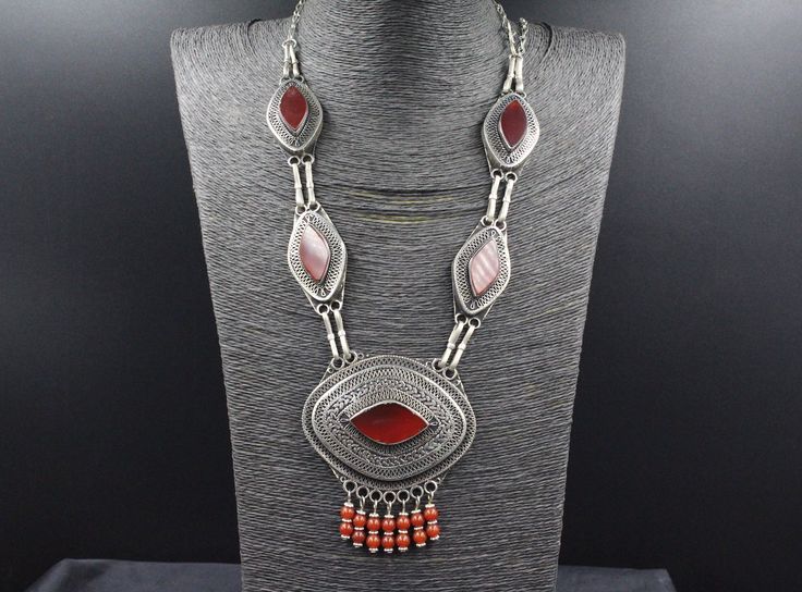 Brilliant! I am offering you Kazakh traditional tribal alpaka charm unique necklace, Its 100% hand crafted workmanship with beautiful compressed carnelian stones & lovely beads.  Please do not hesitate to contact if you have any questions about items or further informations Measures  :  Size of long of the necklace : 29.1" ( 74 cm ) Length of Pendant : 2.4" ( 6.2 cm ) Width : 3" ( 7.5 cm ) Weight : 118.4 Grams, You will get all the pendants shown in pictures. Bohemian Silver Beaded Necklaces With Carnelian, Traditional Handmade Carnelian Necklace, Traditional Silver Carnelian Necklace, Red Bohemian Necklace With Large Pendant, Bohemian Silver Carnelian Necklaces, Silver Carnelian Bohemian Necklaces, Traditional Carnelian Necklace For Gift, Silver Carnelian Bohemian Necklace, Stones Necklace