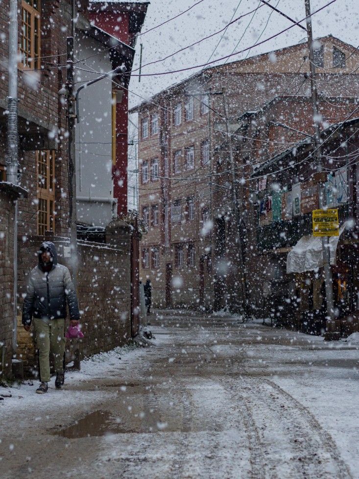 a man walking down a snow covered street