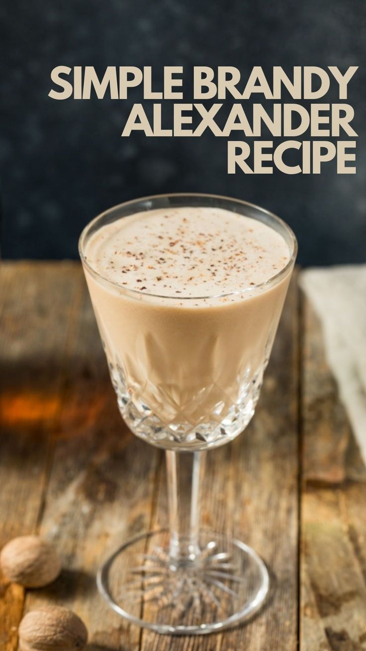 a drink in a glass on top of a wooden table with almonds next to it