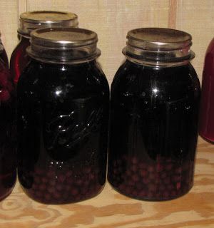 three jars filled with liquid sitting on top of a wooden table