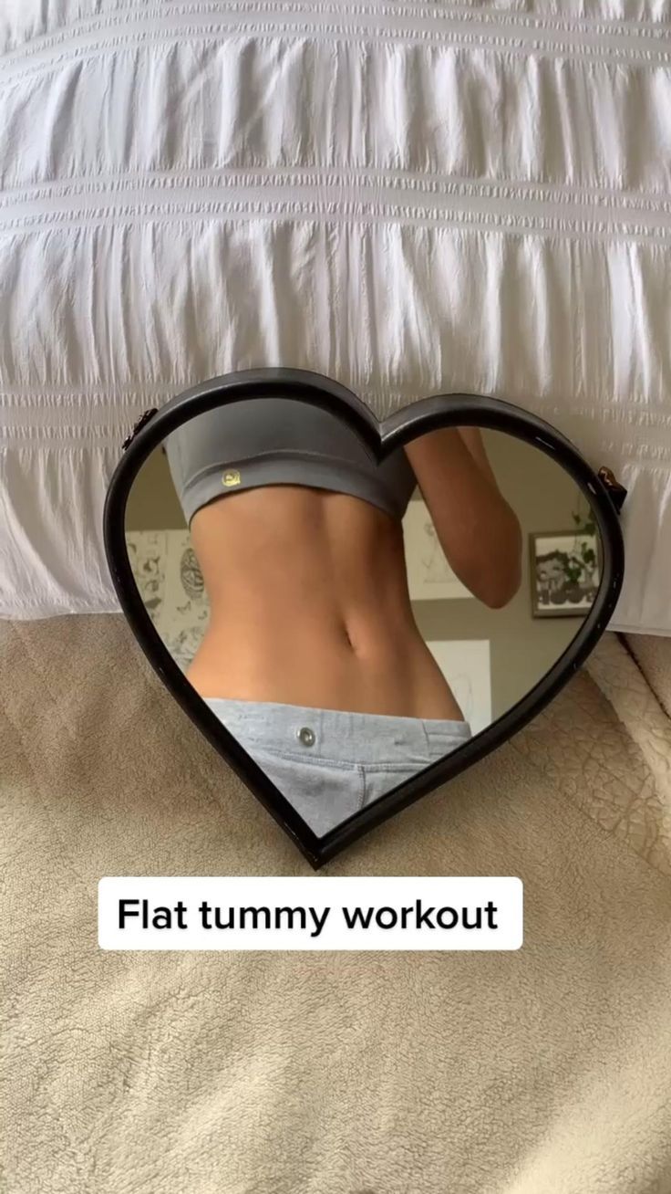 a heart shaped mirror with a woman's stomach in the middle and text that reads, flat tummy workout