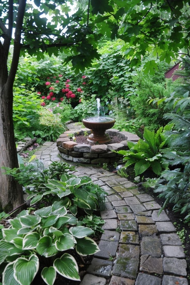 a stone path with a fountain surrounded by greenery