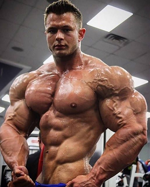 a man standing in the middle of a gym with his hands on his hips and looking at the camera